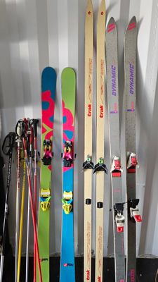 several skis are lined up against a wall in a room