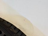a close up of a tire on the side of a white car