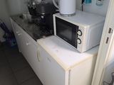 un micro-ondes blanc posé sur un meuble blanc