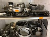 de nombreuses casseroles et poêles sur les étagères de la cuisine