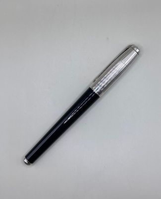 a close up of a pen on a table with a white background