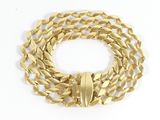 a close up of a gold chain bracelet on a white surface