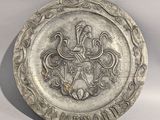 an old silver plate with a coat of arms and a crown on it