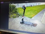 un scooter posé par terre devant un écran d'ordinateur