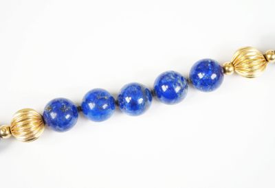 a close up of a blue beaded necklace on a white surface