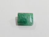 a green emerald stone on a white surface