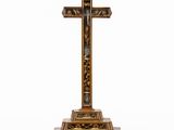 une croix en bois posée sur un socle, sur fond blanc