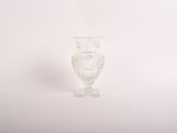 un vase en verre transparent posé sur une surface blanche