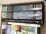 many books stacked on top of each other in a box