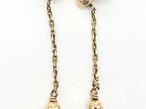 une paire de boucles d'oreilles en perles et or sur fond blanc