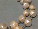 necklace with pearls and gold chain on a gray surface