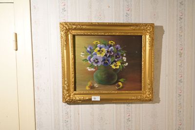 une photo d'un tableau accroché au mur au-dessus des toilettes