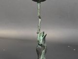 a metal candle holder with a bird on it