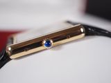 a gold watch with a blue stone on it