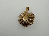a close up of a gold pendant on a white surface
