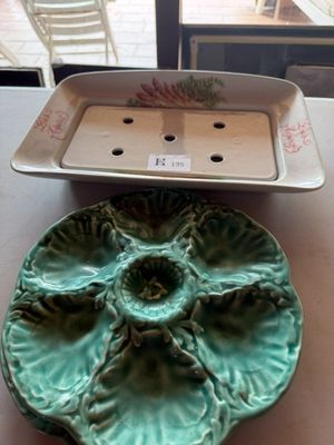 une assiette verte ornée d'une fleur, à côté d'un plateau muni d'un couvercle