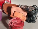 many different purses sitting on a table together
