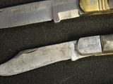 two knives that are laying next to each other on a table