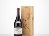the bottle of red wine is next to a wooden box