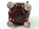 a red ceramic pig that is sitting on a table