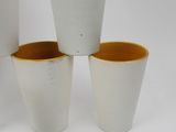 three white and yellow cups sitting on top of each other