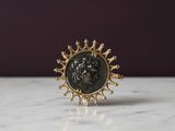 un gros plan d'une bague en or ornée d'un lion