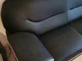 a black leather couch sitting in the corner of a room