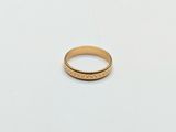 a close up of a gold ring on a white surface