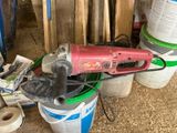 a picture of a red electric sander sitting on top of a bucket