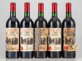 quatre bouteilles de vin rouge sont alignées sur une table