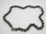 un collier de perles noires avec un fermoir en diamant