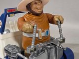 a figurine of a man in a cowboy hat riding a toy truck