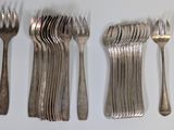 several forks and spoons are lined up on a white surface