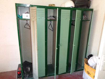 several green lockers are lined up in a room next to a white wall