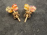 a pair of colorful earrings on a black surface