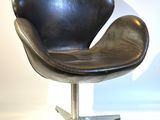 un fauteuil en cuir noir avec un piètement en métal sur fond blanc