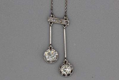 une photo représentant une paire de pendentifs en diamant suspendus à une chaîne