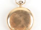 an antique gold pocket watch with a chain hanging from it ' s side