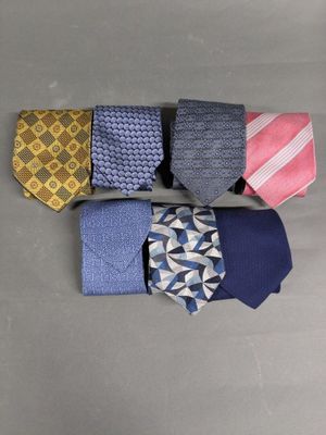 four different colored ties laid out in a row on a gray surface
