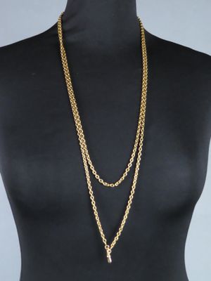 a mannequin torso with a gold chain necklace on it