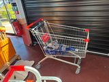a shopping cart that is sitting in front of a garage door