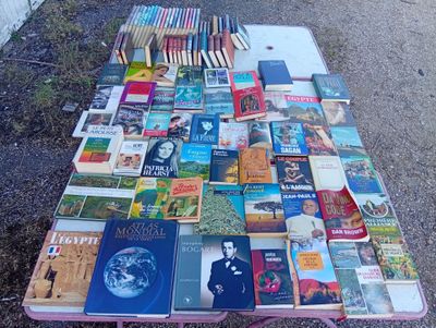 many books on a table outside on the ground