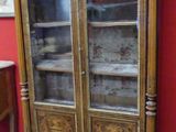 un meuble en bois avec des portes en verre dans une pièce