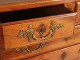 a wooden chest of drawers with brass handles on it