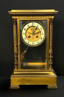 a gold clock that is sitting on a black table