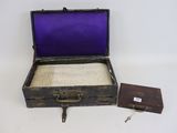 an old suitcase with a purple cover and a small wooden box