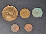 four different coins are shown on a table with a black background