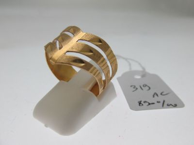 an image of a gold ring on a white surface with a price tag