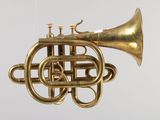 a brass instrument hanging from a string on a white background