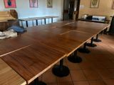 a long wooden table with black metal legs in a room